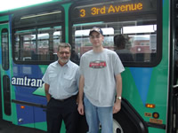 A picture of Justin Hickox and his favorite AMTRAN driver Sam in front of an AMTRAN bus